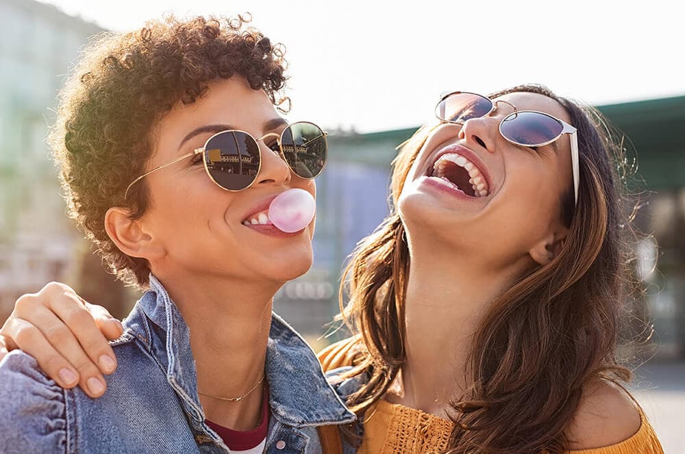 Frauen mit sonnenbrillen lachen zusammen