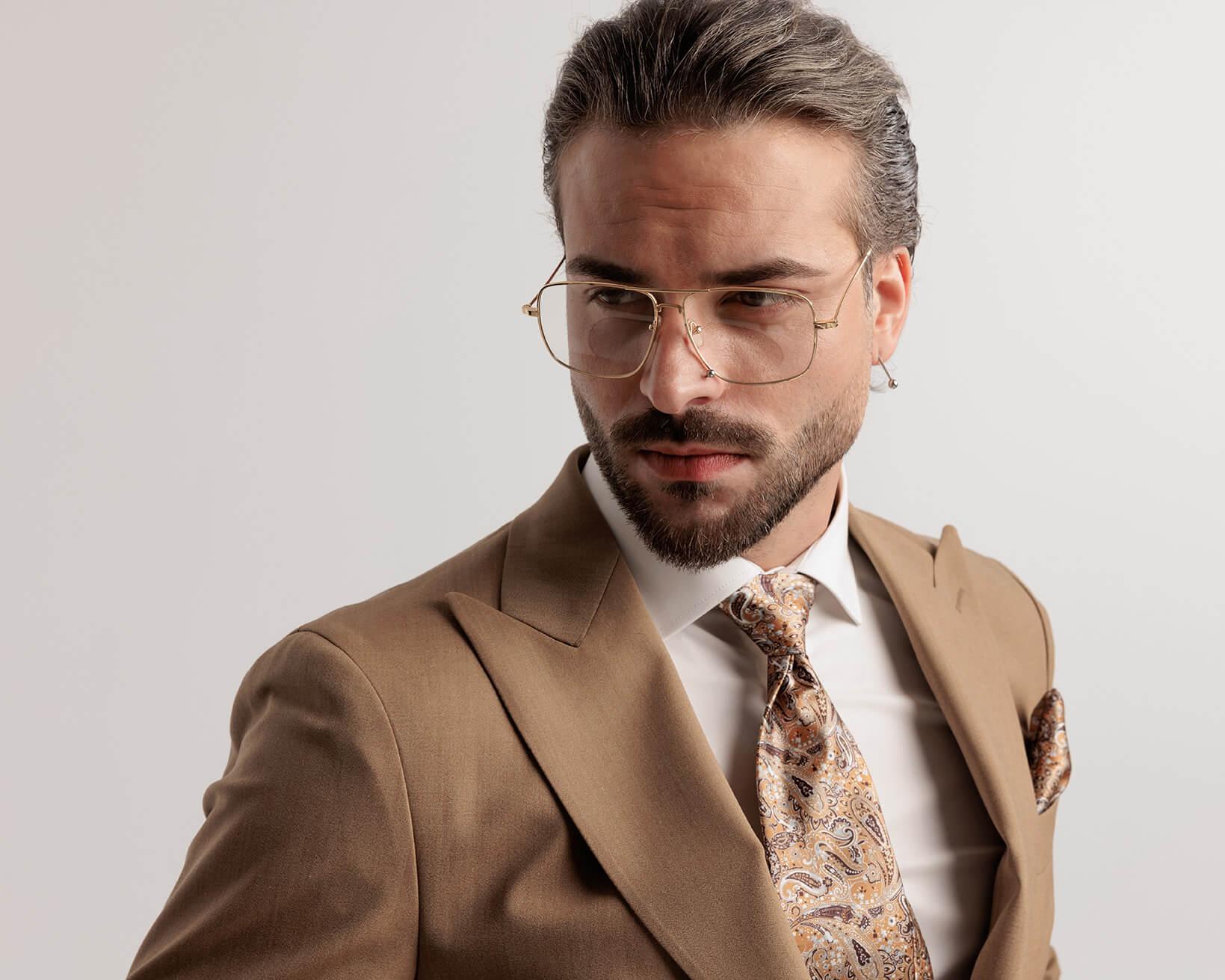 Mann mit goldener doppelsteg korrektionsbrille und beigen anzug